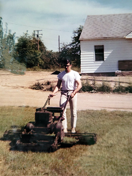 man mowing grass in the 1960's